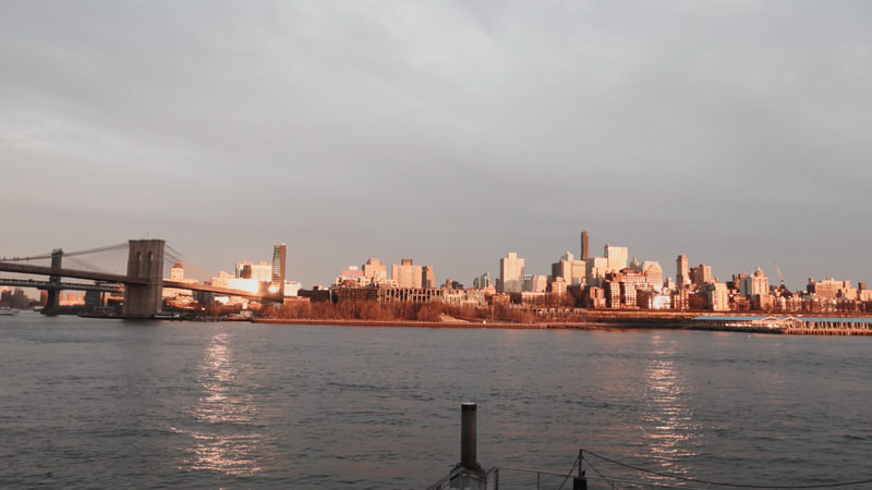 Brooklyn Bridge and the Manhattan skyline in warm evening light.